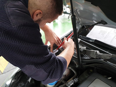 ITV technician makes etching of stamped VIN number on Volkswagen Golf Cabrio during import test ITV technician under bonnet
